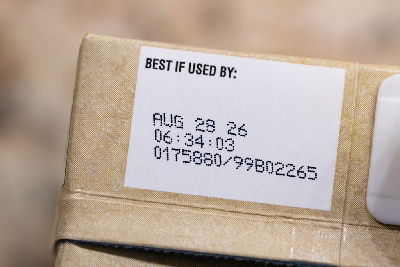 Food packages in a grocery store refrigerator showing Best If Used By and Use By date labels under California Assembly Bill 660 which took effect July 1 2026 banning consumer-facing Sell By dates