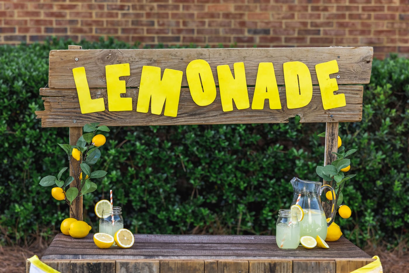 Children running a lemonade stand on a sidewalk representing the Michigan House of Representatives unanimously passing House Bill 6007 to exempt minors from food service permits for lemonade stands