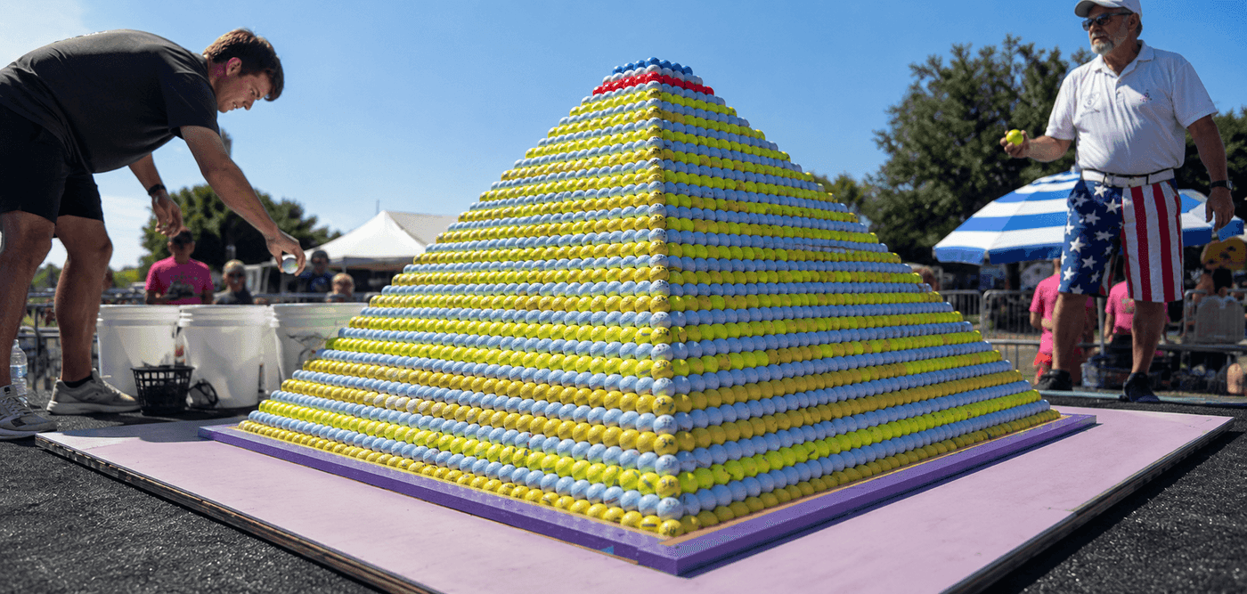 A pyramid of 19019 golf balls stacked by Michael Furrh Debbie Reynolds and Terri Janak at the Benbrook Heritage Fest in Texas setting the Guinness World Record for largest golf ball pyramid